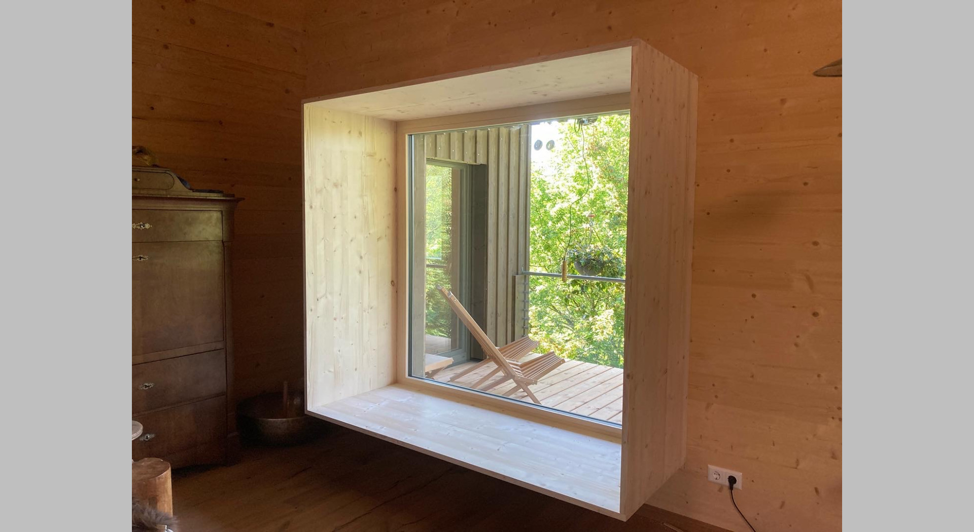 Ein Loungefenster 2 Meter x 2 Meter im Wohnzimmer mit Blick in die Natur 